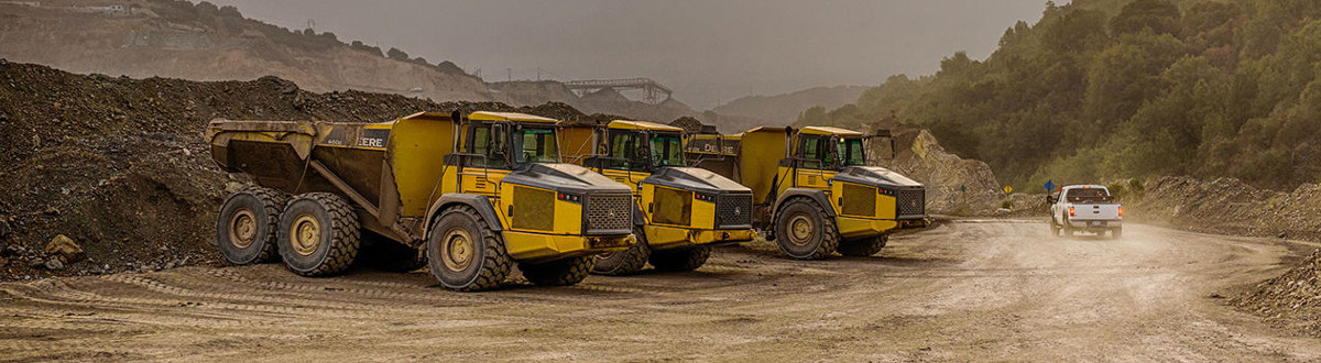 2018 John Deere Articulated Dump Trucks parked next to a construction site